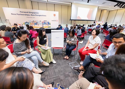 Minister of State Gan Siow Huang speaking with participants during a small group discussion.